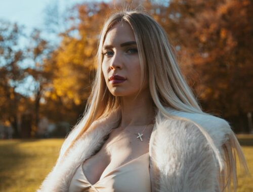 Portrait of elegant woman in fur coat in Munich park during fall. Beautiful autumn colors.
